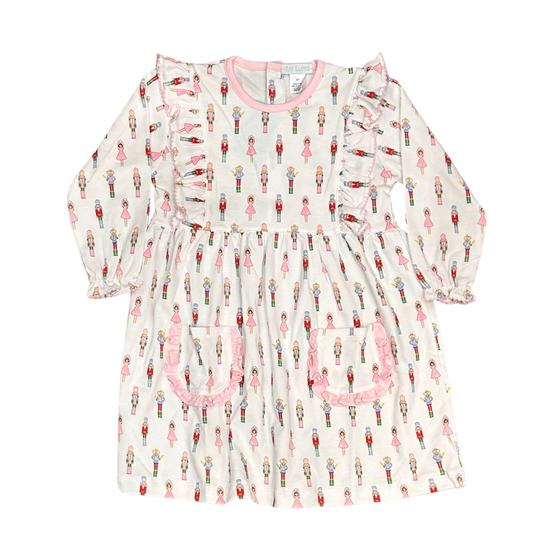 girls white knit dress with nutcracker pattern and ruffle and pockets