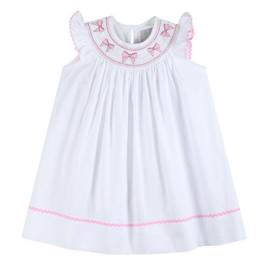 girls white bishop dress with pink bow smocking at neck and pink ric rak and flutter sleeves